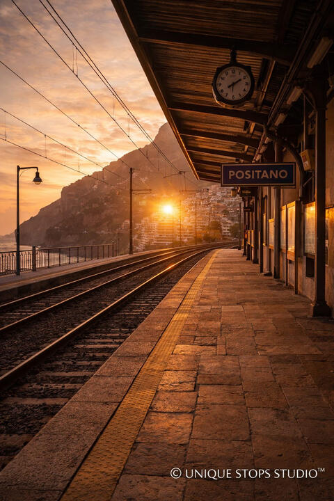 Golden hour at Positano train station on Italy’s Amalfi Coast, empty platform with coastal tracks and sunset light — premium travel photography licensed by Unique Stops Studio™ for film, advertising, and brand campaigns.